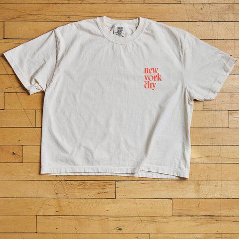 White t-shirt with 'New York City' text on wooden floor