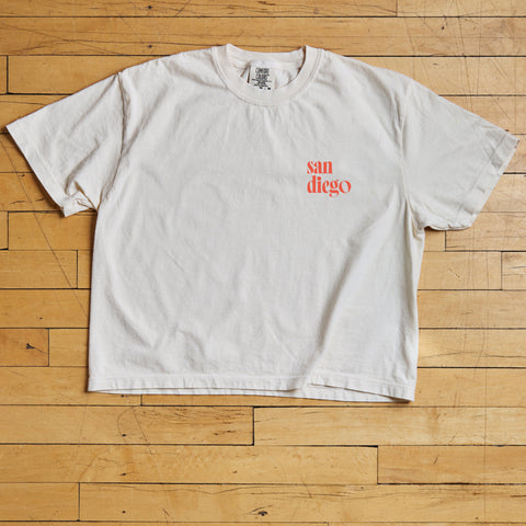 White t-shirt with 'san diego' print on a wooden floor