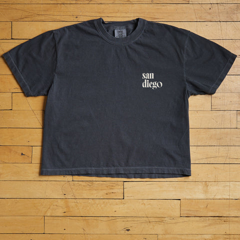 Black t-shirt with 'san diego' text on a wooden floor