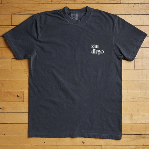 Black t-shirt with 'San Diego' text on a wooden floor