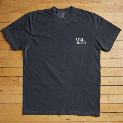 Black t-shirt with 'savannah' text on a wooden floor