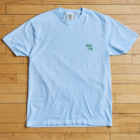 Light blue t-shirt with tucson text on a wooden floor