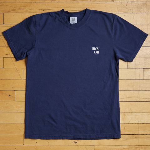 Navy blue t-shirt with a tucson logo on a wooden floor