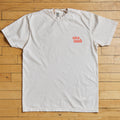 White t-shirt with red text on a wooden floor