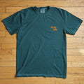 Teal t-shirt with a Sioux Falls logo on a wooden floor