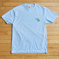 Light blue t-shirt with 'Sioux Falls' text on a wooden floor