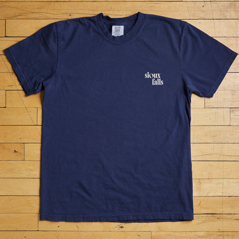 Navy blue t-shirt with 'Sioux Falls' text on a wooden floor