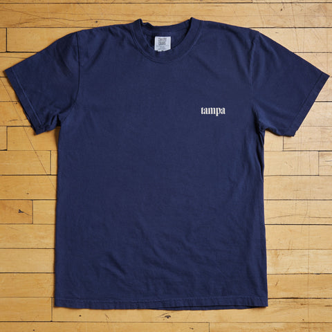 Navy blue t-shirt with a tampa logo on a wooden floor