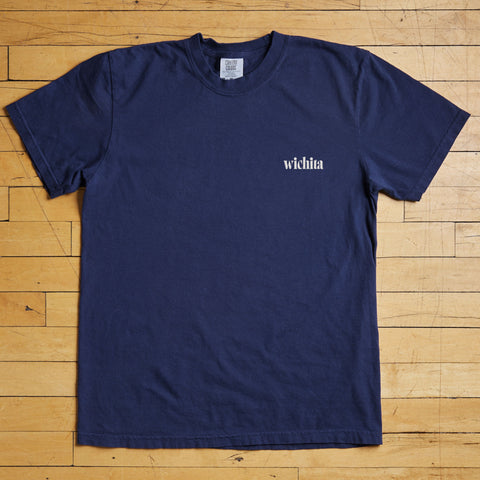 Navy blue t-shirt with 'wichita' text on a wooden floor